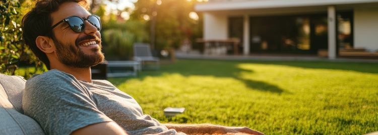 Blog of How Butyrate Helps You Think, Feel, and Be Yourself Again which have image A man with a beard and sunglasses reclines comfortably on outdoor furniture in a sunlit backyard. 