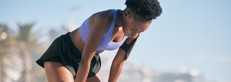 Blog of Functional Thiamine (B1) Deficiency: 7 Signs You Shouldn’t Ignore which have image A woman in athletic wear leans forward with her hands on her knees, catching her breath.