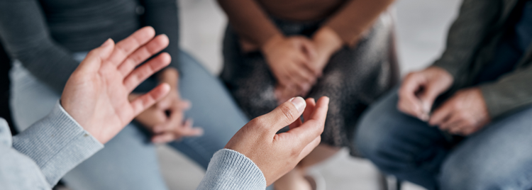 Blog of How Emotional Trauma Affects Your Cells and What You Can Do to Heal which have image  A close-up of a person's hands gesturing while speaking in a support group or therapy session.